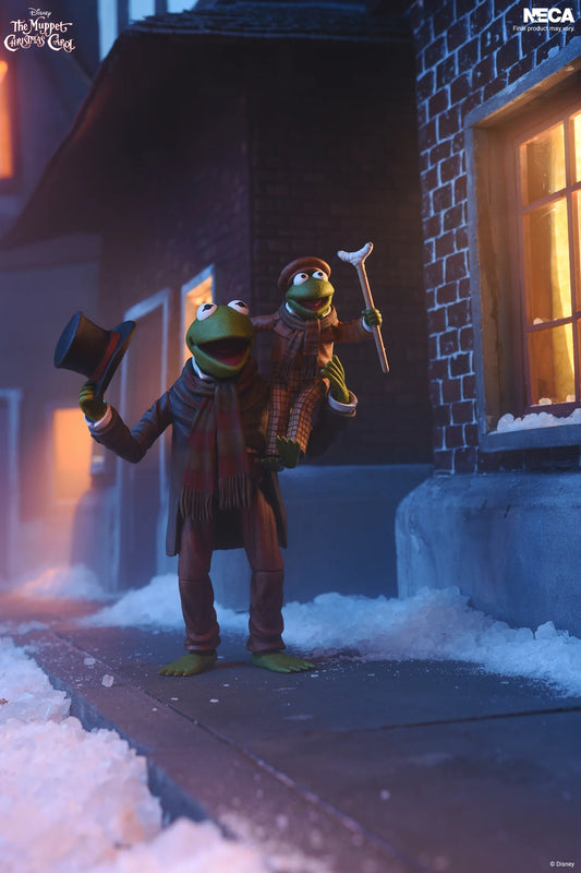 *PRE-ORDER The Muppets Christmas Carol 7 Inch Scale Ultimate Action Figure 2 Pack - Kermit As Bob Cratchit & Robin As Tiny Tim